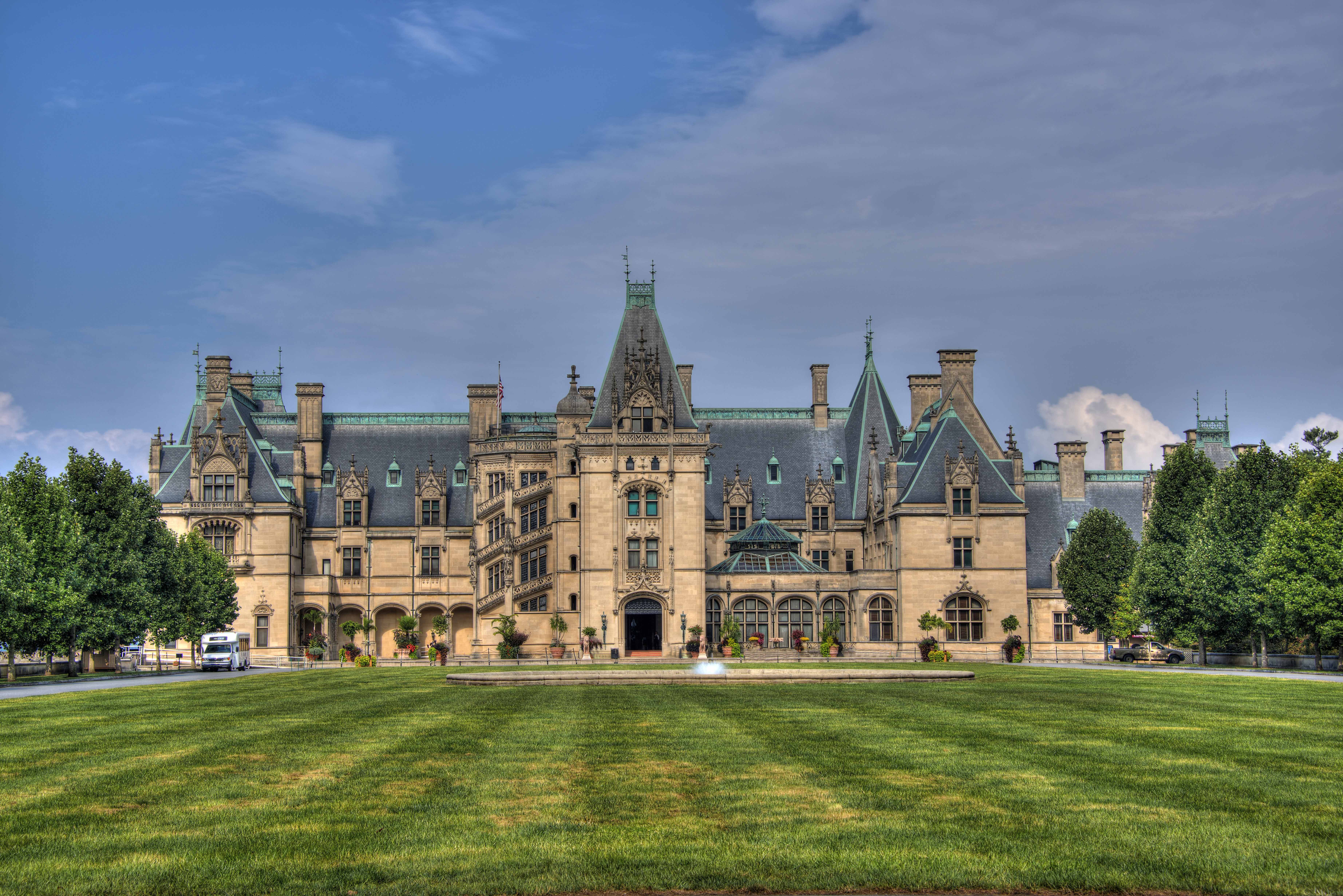 a large castle like building sitting on top of a lush green field